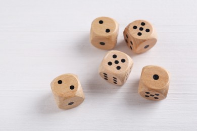 Many game dices on white wooden table, above view. Space for text