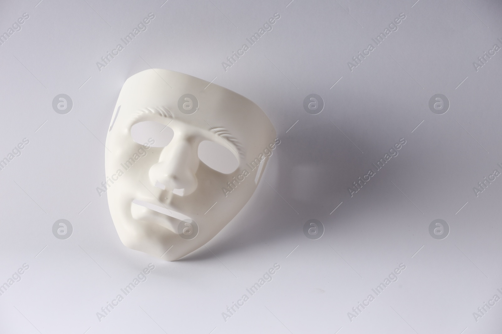 Photo of Plastic face mask on white background, space for text. Theatrical performance