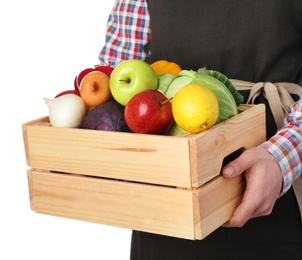 Photo of Man holding wooden crate filled with fresh vegetables and fruits against white background, closeup