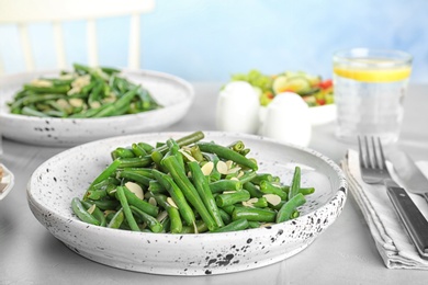 Tasty green beans with almonds served for dinner on table