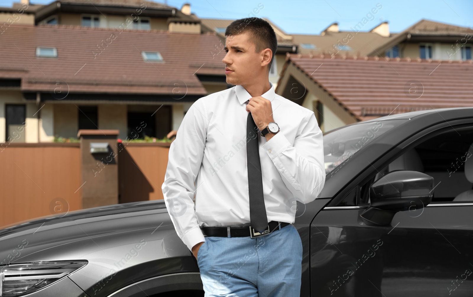 Photo of Attractive young man near luxury car outdoors