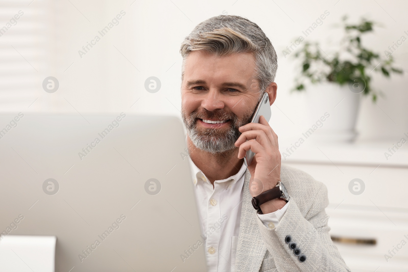 Photo of Professional accountant talking on phone while working in office