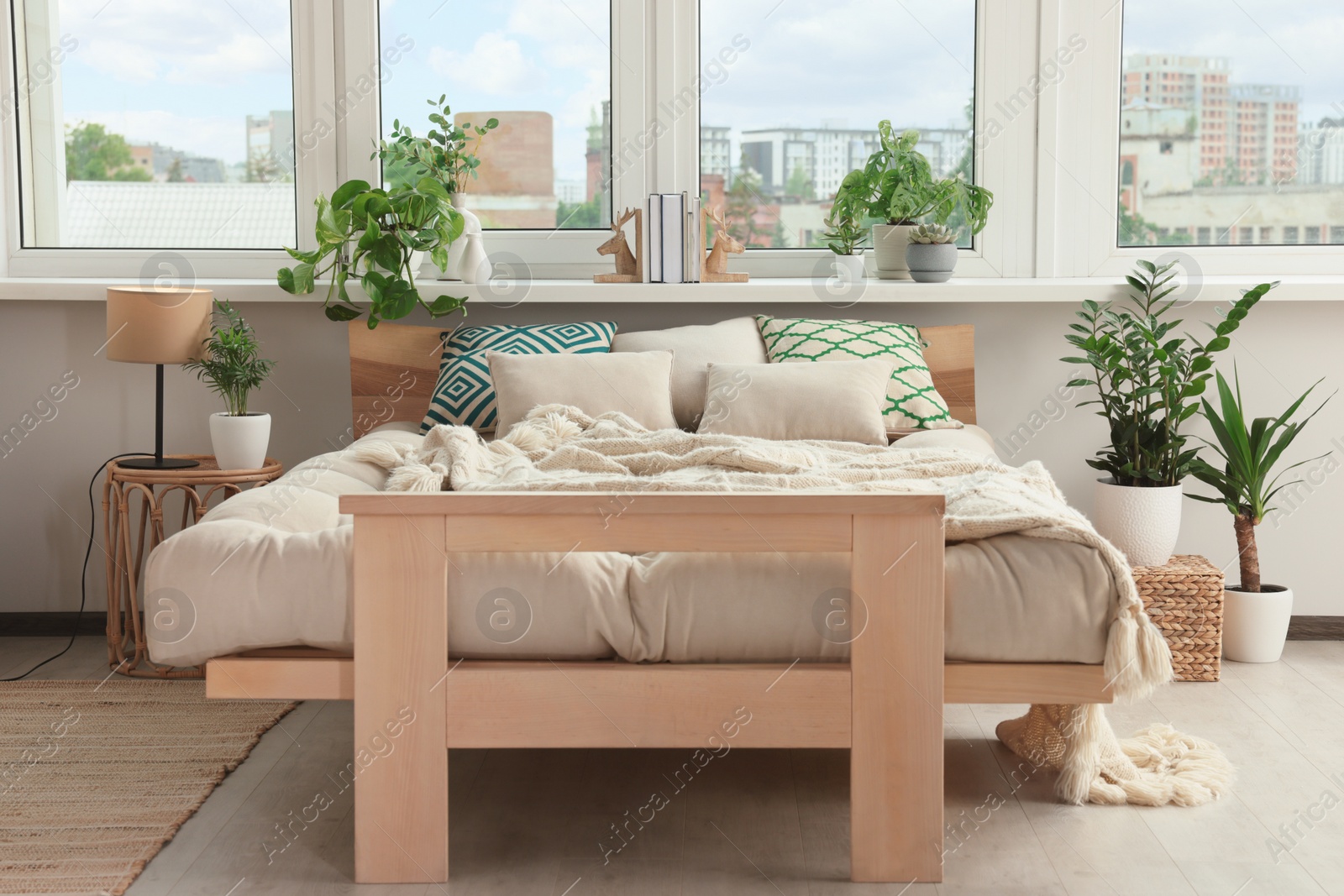 Photo of Stylish bedroom interior with beautiful house plants. Home design idea