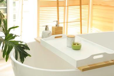 Photo of Scented candles on tray for tub in bathroom. Interior design