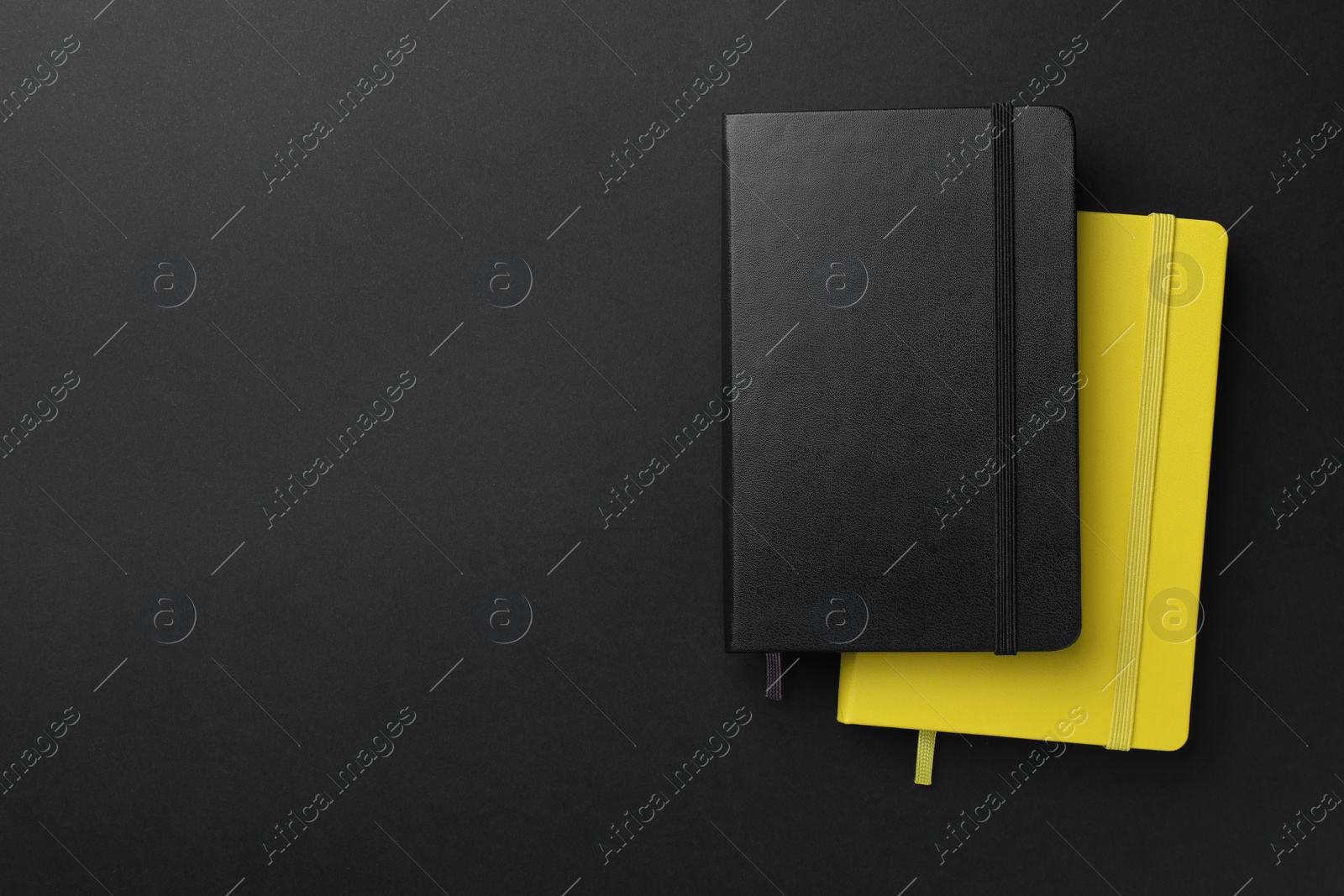 Photo of Different notebooks on black background, top view. Space for text