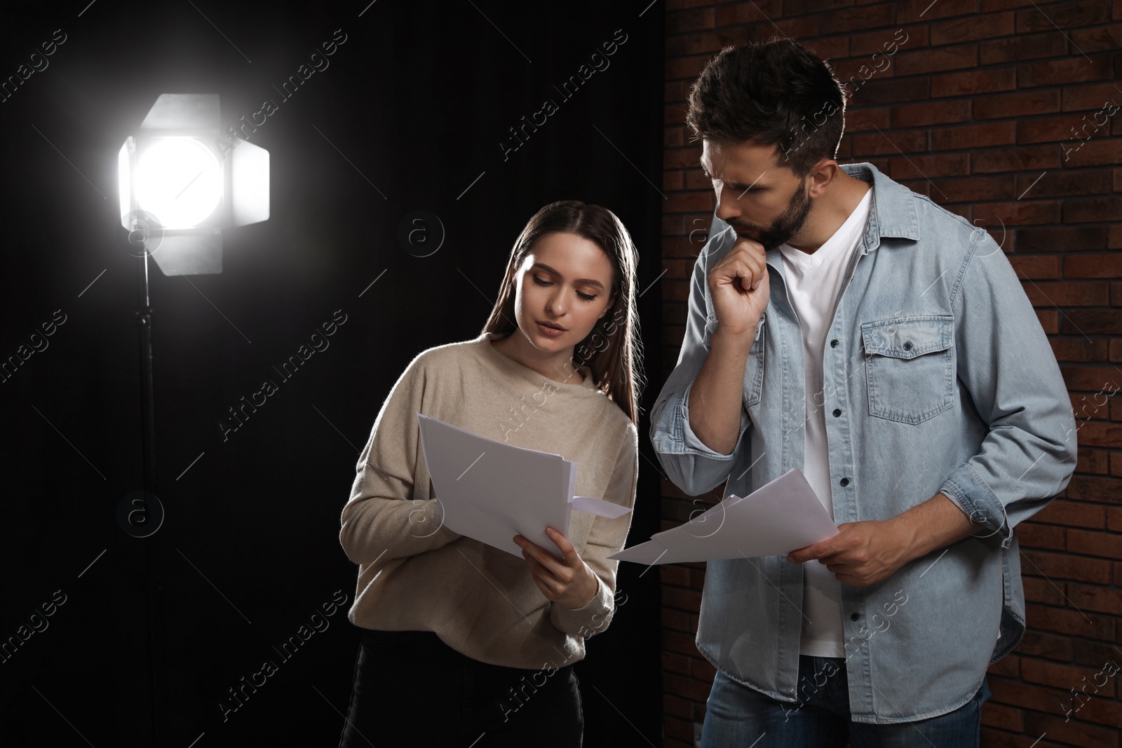 Photo of Professional actors reading their scripts during rehearsal in theatre