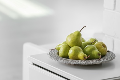 Photo of Fresh ripe pears on white table in room. Space for text