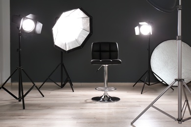 Photo of Modern chair in photo studio with professional equipment