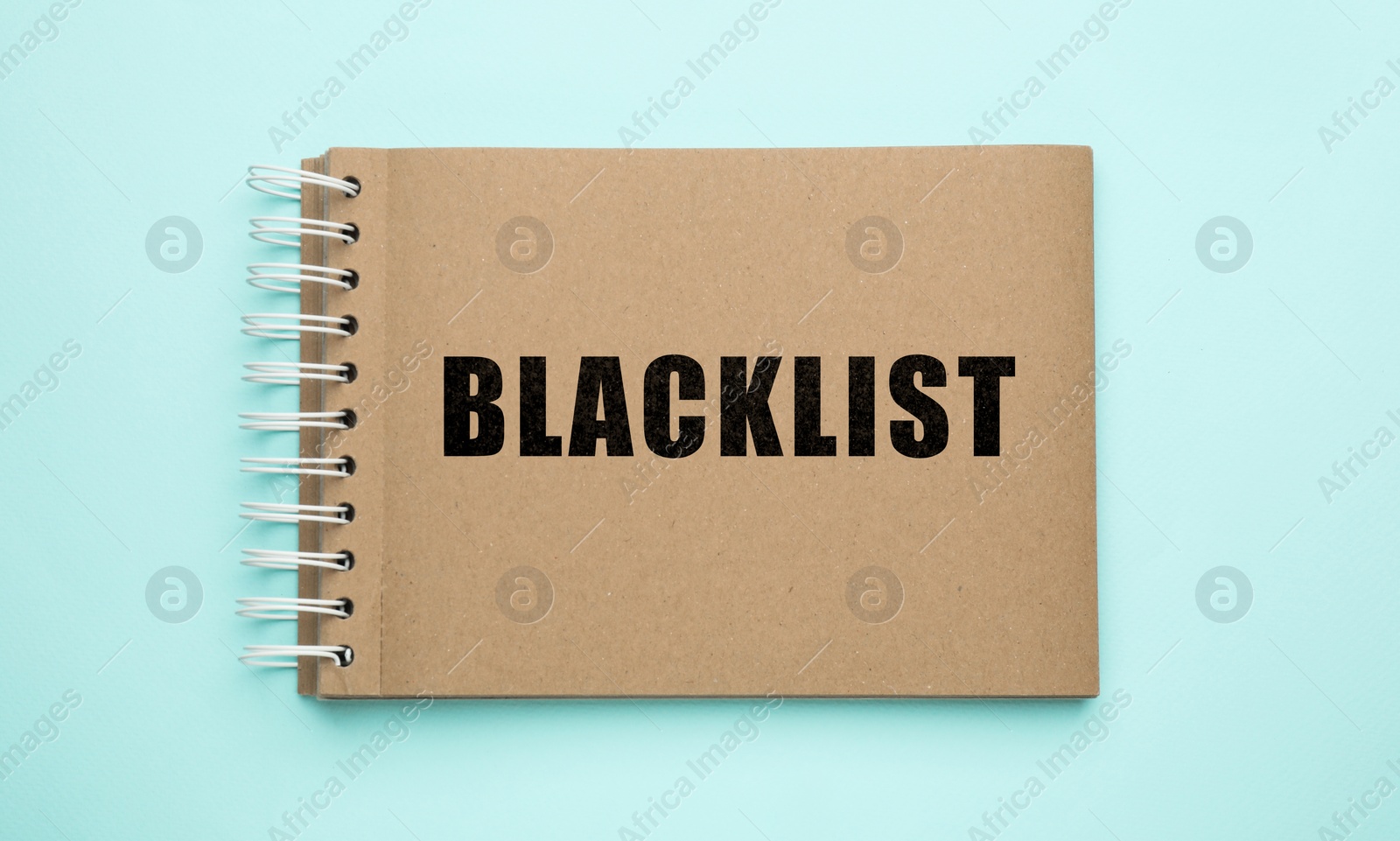 Image of Word Blacklist written in notepad on light blue background, top view