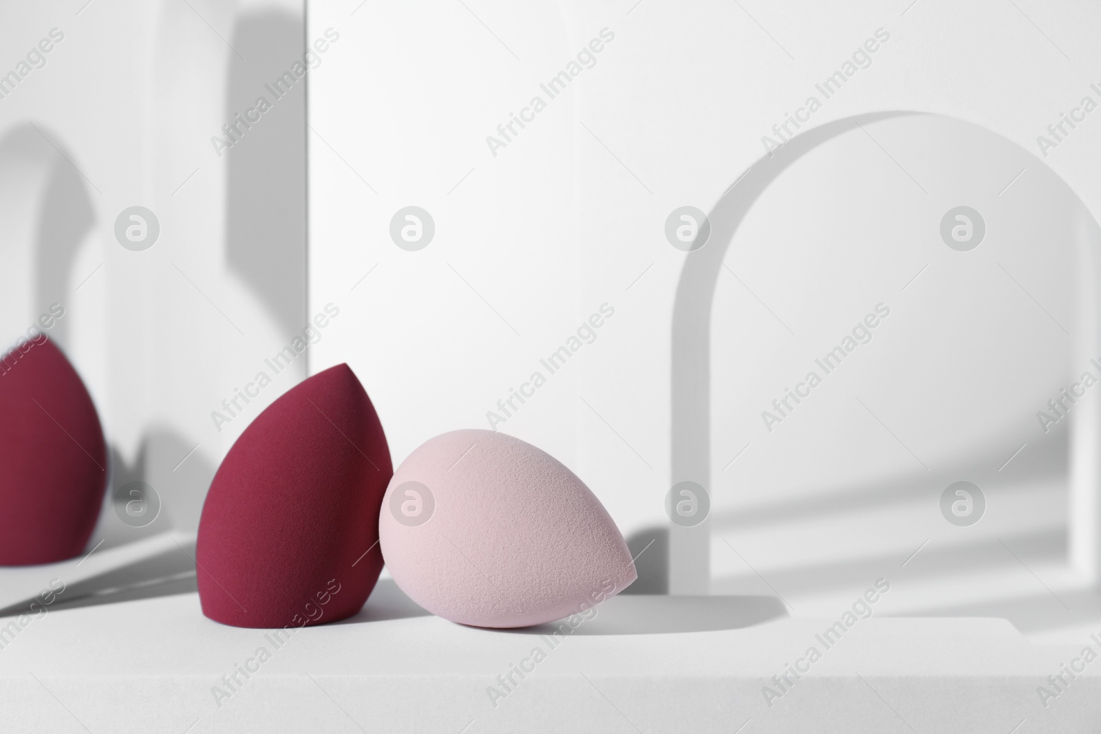 Photo of Stylish presentation of makeup sponges on white background