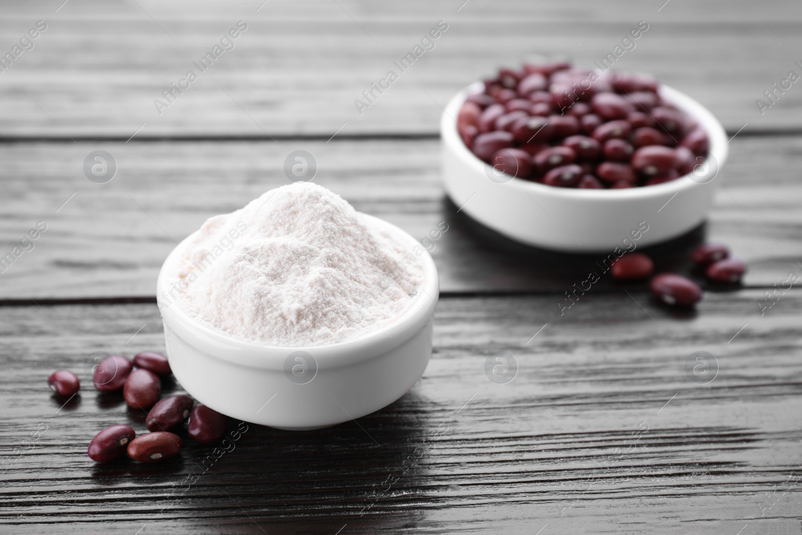 Photo of Kidney bean flour and seeds on wooden table, closeup