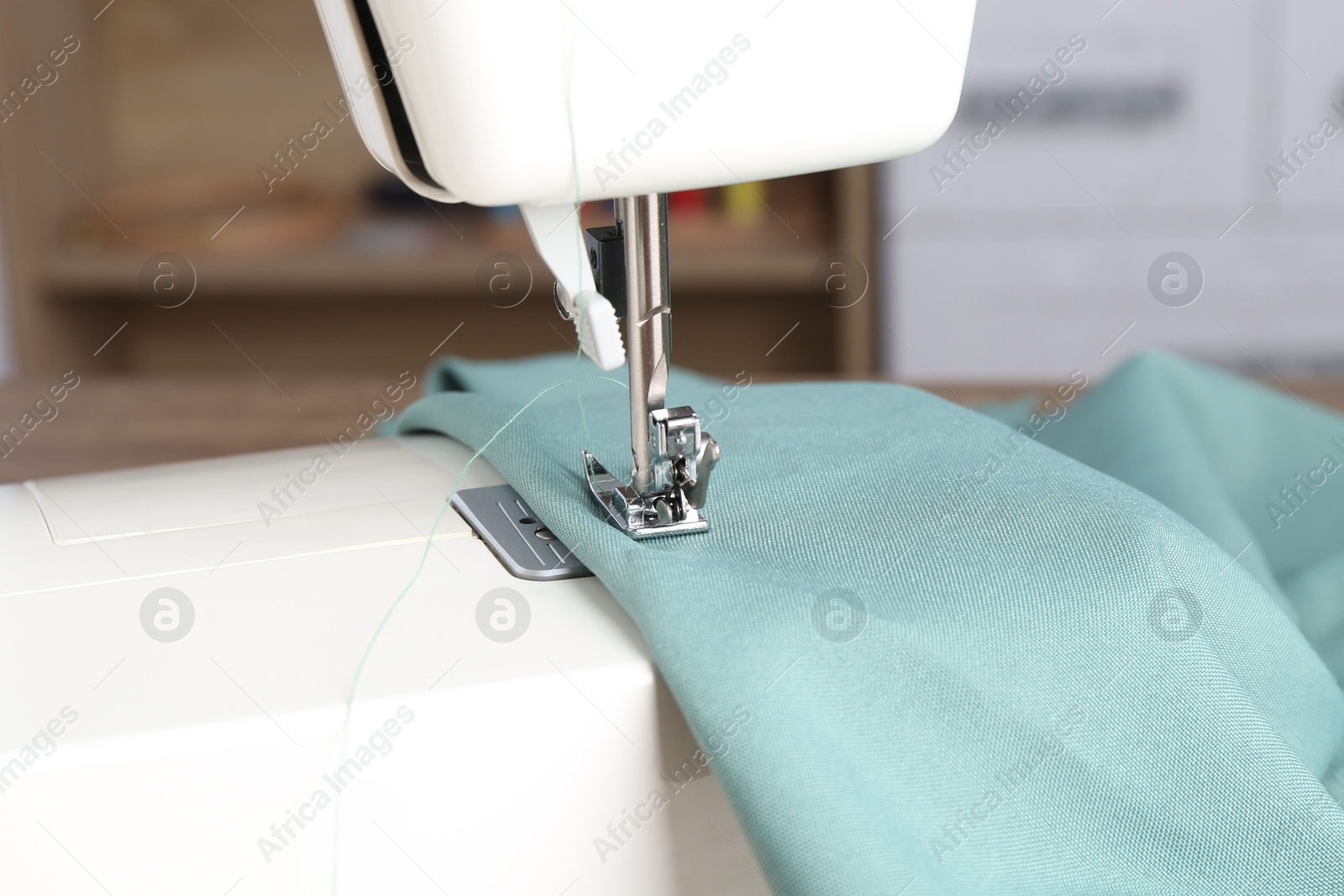 Photo of White sewing machine with color fabric indoors, closeup