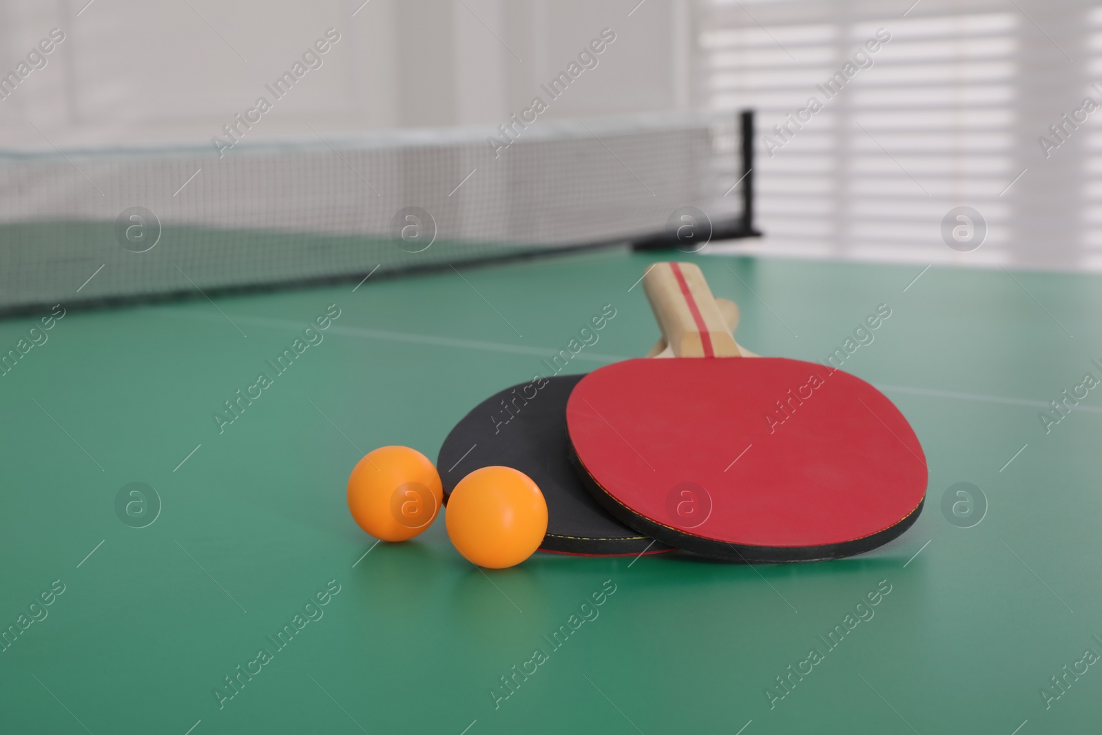 Photo of Rackets and balls on ping pong table indoors