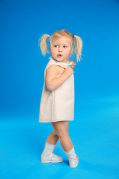 Cute little girl posing on light blue background