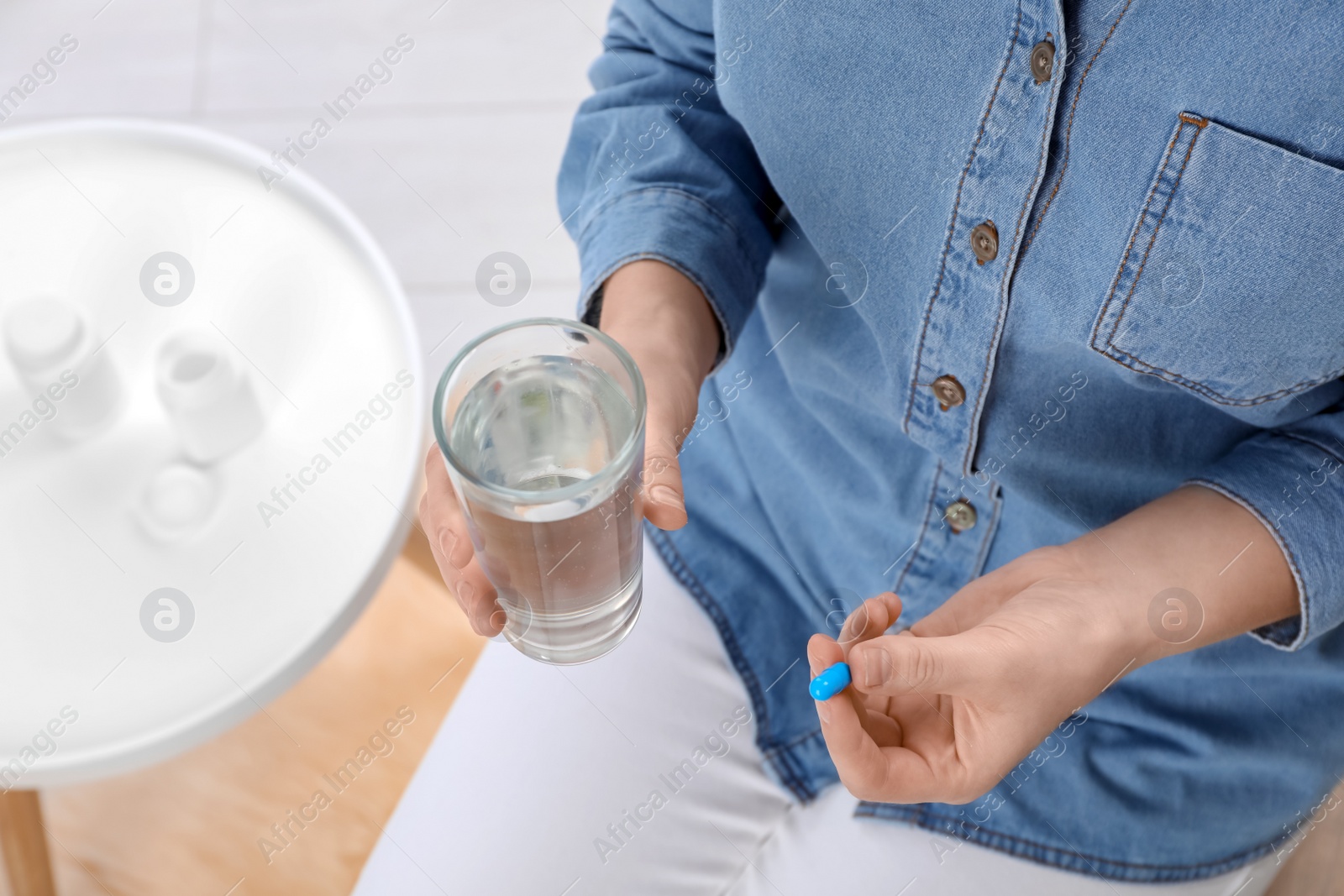 Photo of Young woman with pill and glass of water, closeup