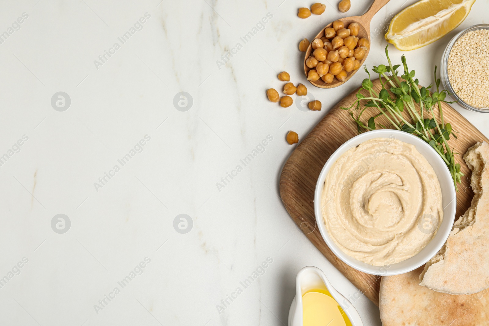 Photo of Delicious hummus and different ingredients on white marble table, flat lay. Space for text