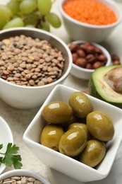 Photo of Different products high in natural fats on light table, closeup