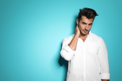 Photo of Young man with trendy hairstyle posing on color background