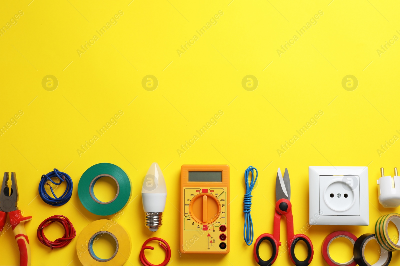 Photo of Flat lay composition with electrician's tools and accessories on yellow background, space for text