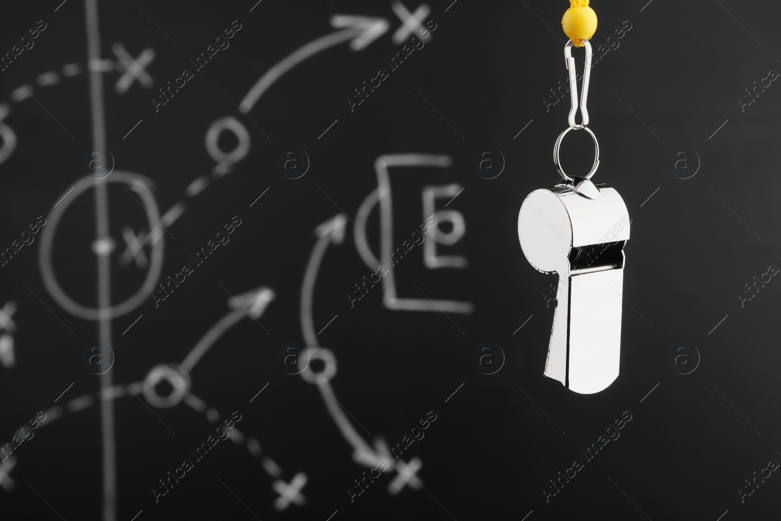 Photo of Referee whistle against chalkboard with game scheme, closeup. Space for text