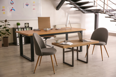 Stylish office interior with large wooden table