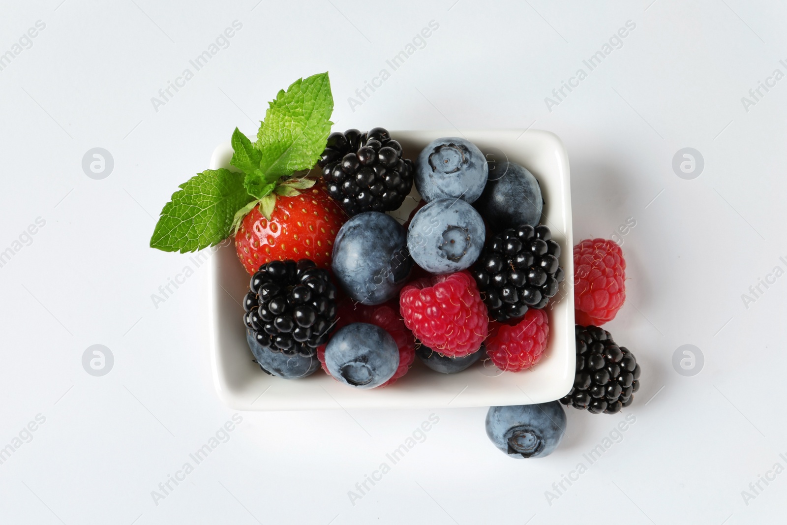 Photo of Bowl with raspberries and different berries on white background