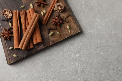 Photo of Board with different aromatic spices on light table, top view. Space for text