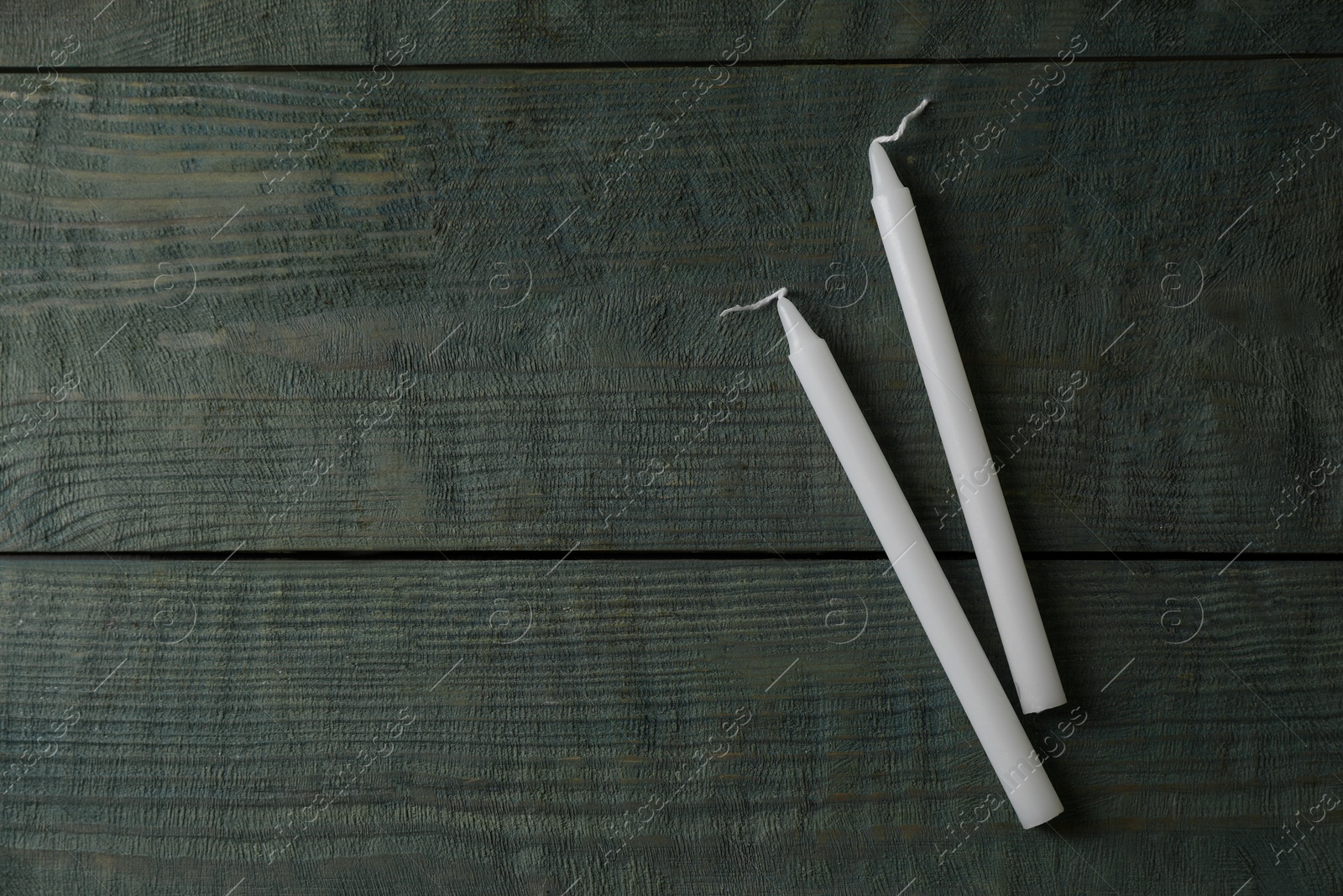 Photo of Church wax candles on old wooden table, flat lay. Space for text