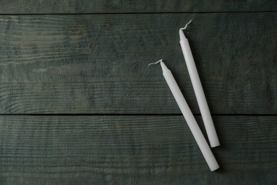 Church wax candles on old wooden table, flat lay. Space for text