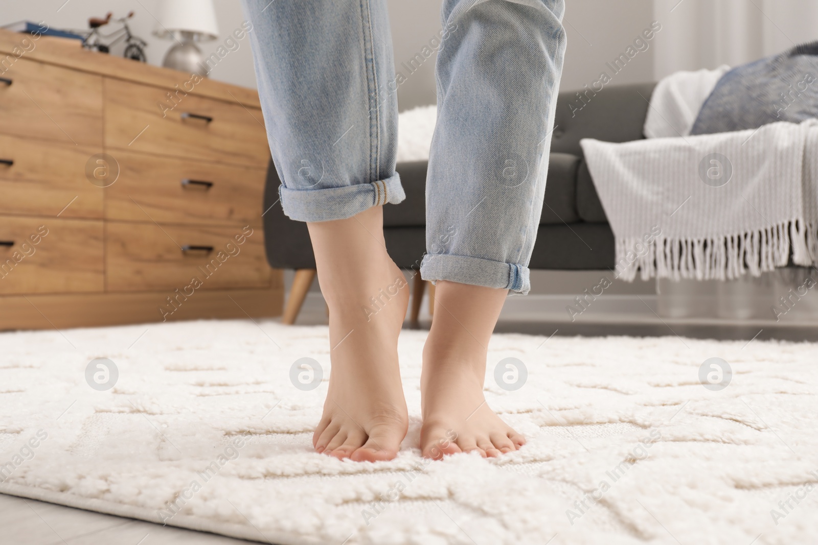 Photo of Woman standing on beige carpet in room, closeup