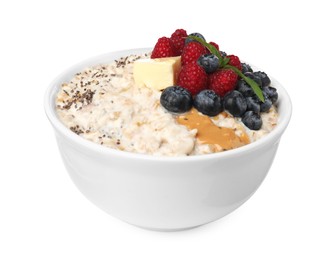 Photo of Tasty boiled oatmeal with berries, chia seeds and peanut butter in bowl isolated on white
