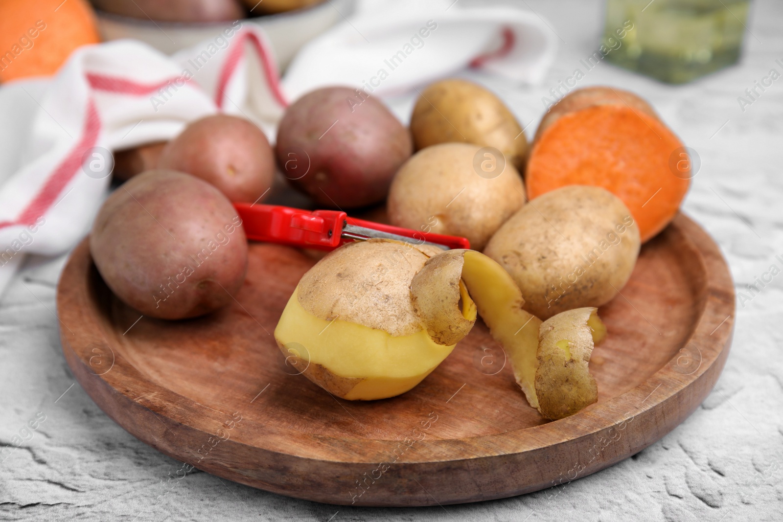 Photo of Different types of fresh potatoes on white textured table, closeup