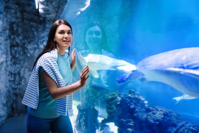 Image of Beautiful woman near big aquarium in oceanarium