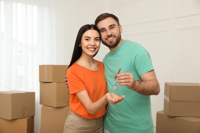 Happy young couple with key in new house