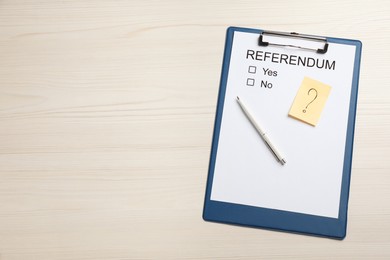 Photo of Referendum ballot with clipboard and pen on white wooden table, flat lay. Space for text