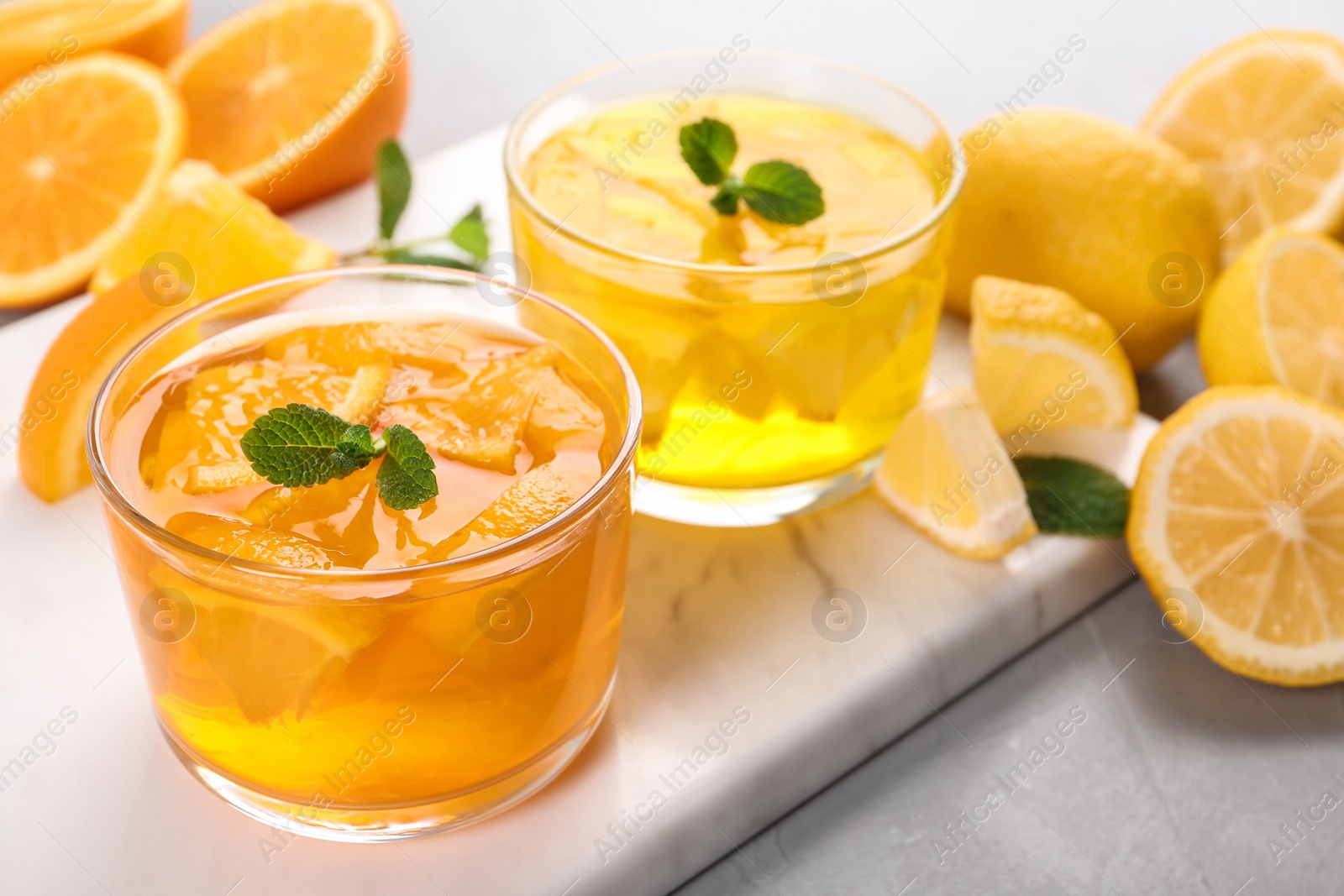 Photo of Glasses of tasty jelly served on light table. Space for text