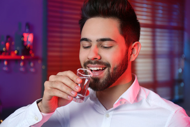 Photo of Young man with Mexican Tequila shot in bar