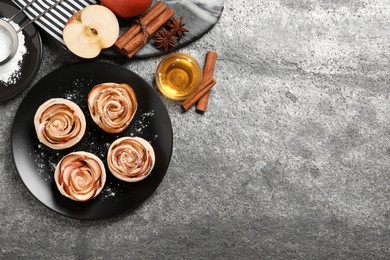 Photo of Freshly baked apple roses on grey table, flat lay. Space for text