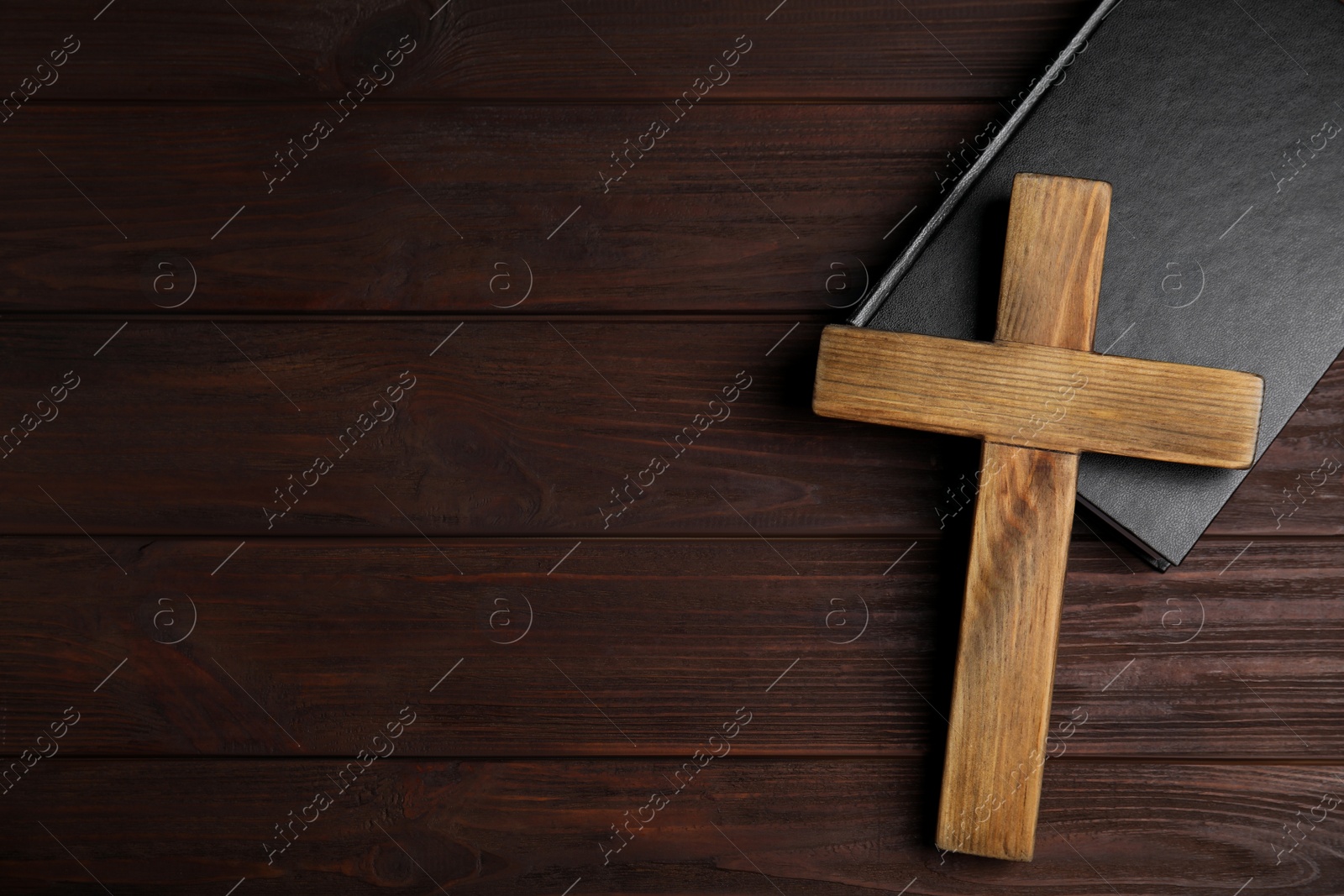 Photo of Christian cross and Bible on wooden background, top view with space for text. Religion concept