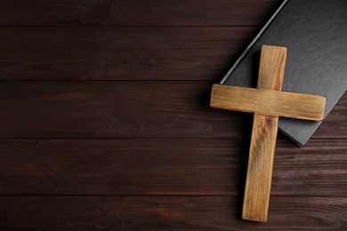 Photo of Christian cross and Bible on wooden background, top view with space for text. Religion concept
