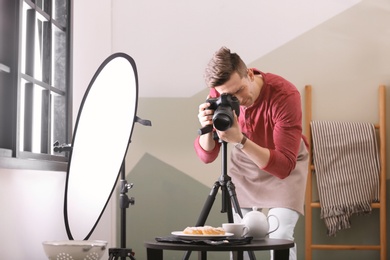 Photo of Young man taking picture of food in photo studio