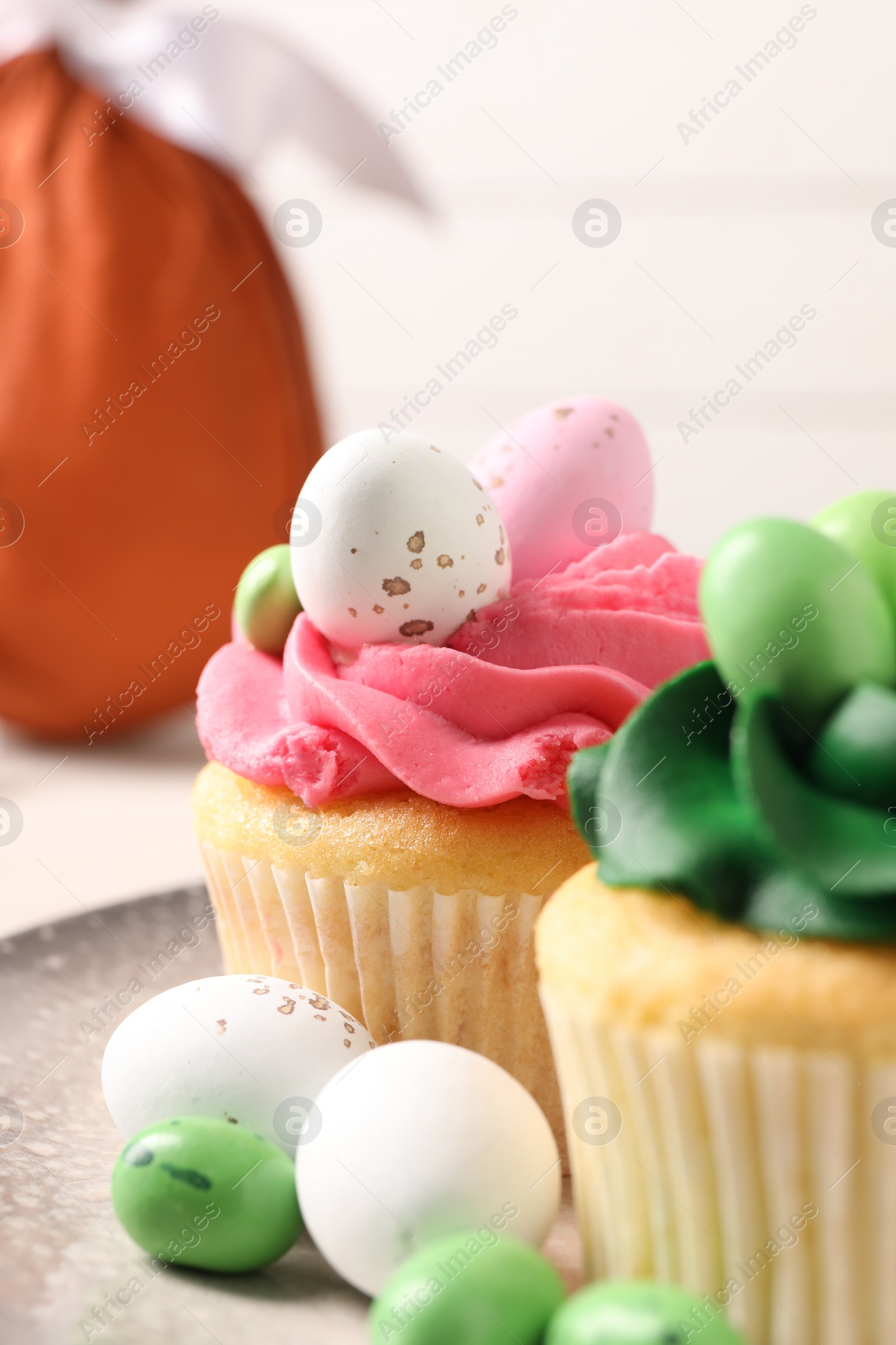 Photo of Tasty cupcakes with Easter decor on table, closeup