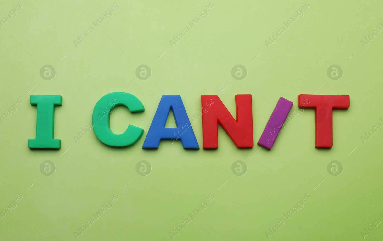 Photo of Motivation concept. Changing phrase from I Can't into I Can by adding slash symbol on light green background, flat lay