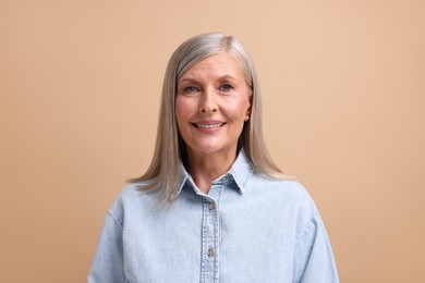 Photo of Portrait of beautiful middle aged woman on beige background