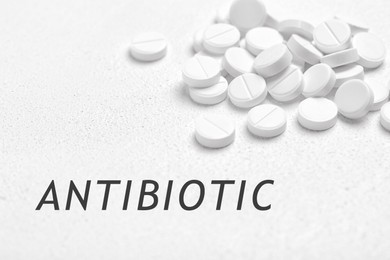 Image of Word Antibiotic and pills on white background, closeup