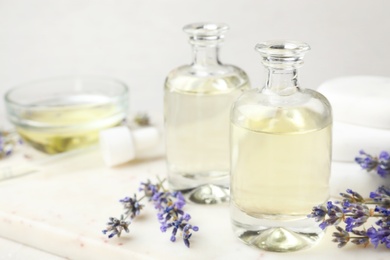 Photo of Bottles with natural lavender essential oil on table, space for text