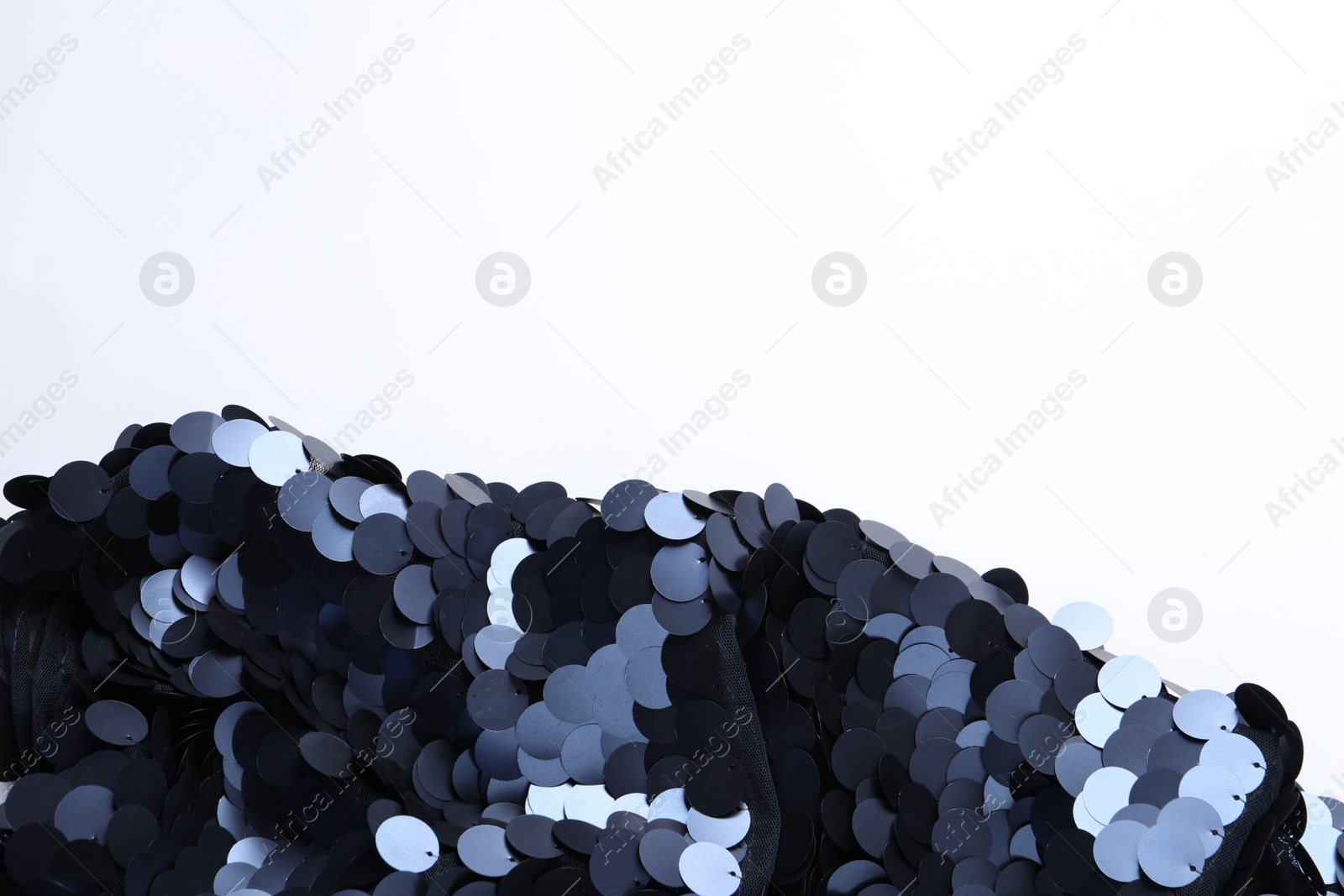 Photo of Beautiful shiny sequin fabric on white background, top view. Space for text