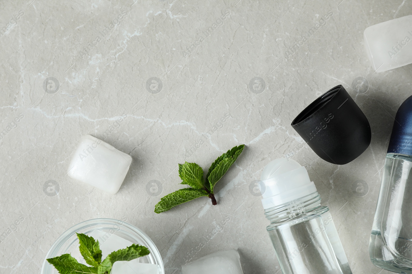 Photo of Flat lay composition with roll-on deodorants on light grey marble table