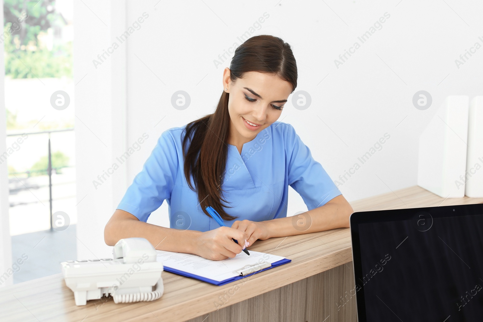 Photo of Female medical assistant at workplace in clinic. Health care service