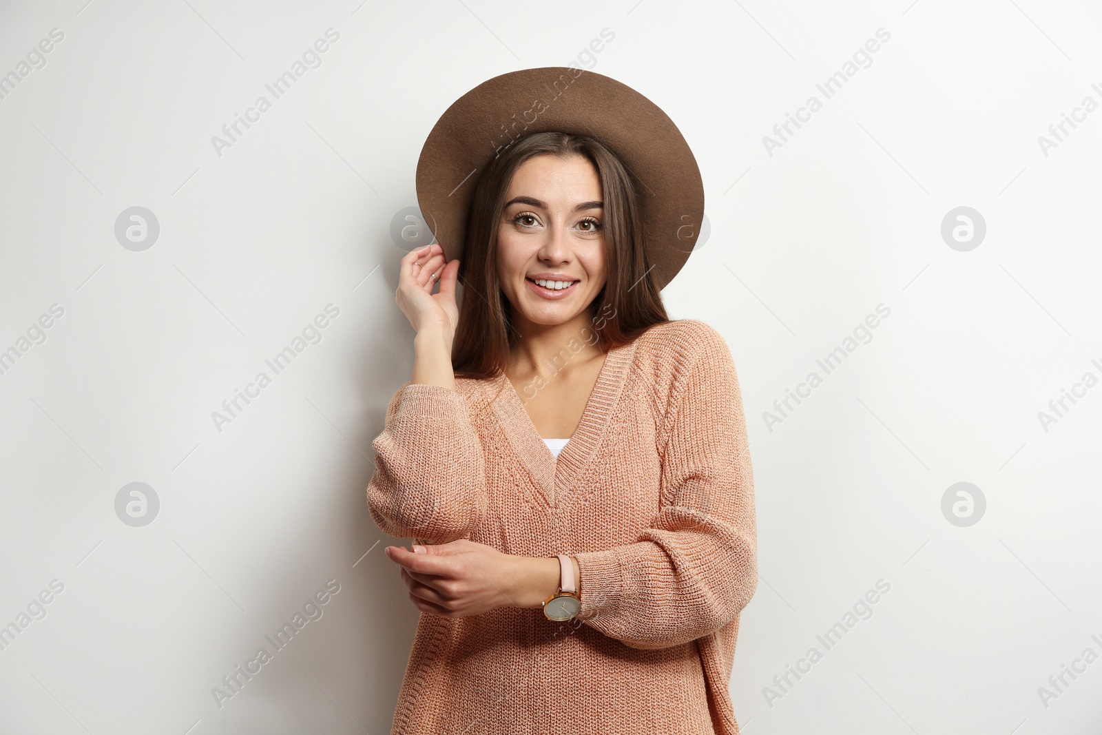 Photo of Beautiful young woman in warm sweater with hat on white background